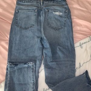 Jeans with rips on the front and one on the back